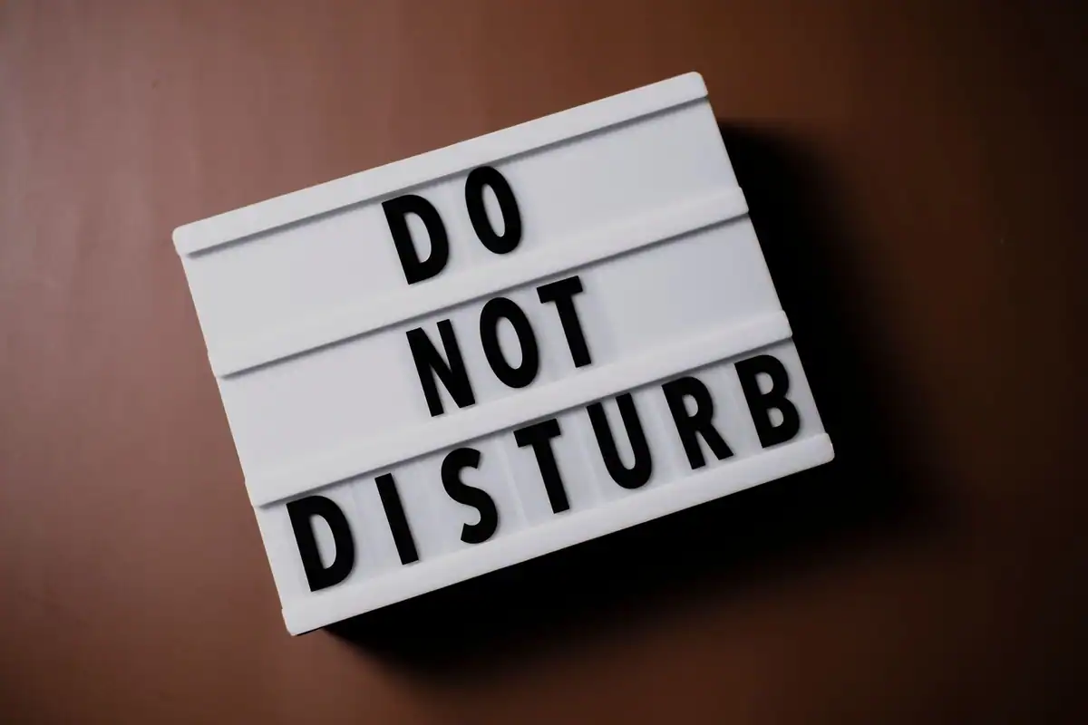 Panou luminos cu mesajul Do Not Disturb pe fundal maro, simbol al intimității