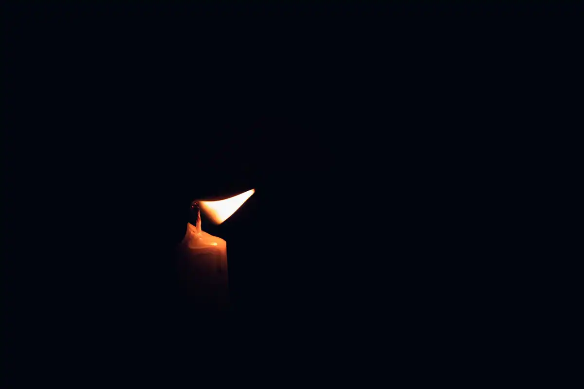 O singură lumânare aprinsă care luminează întunericul