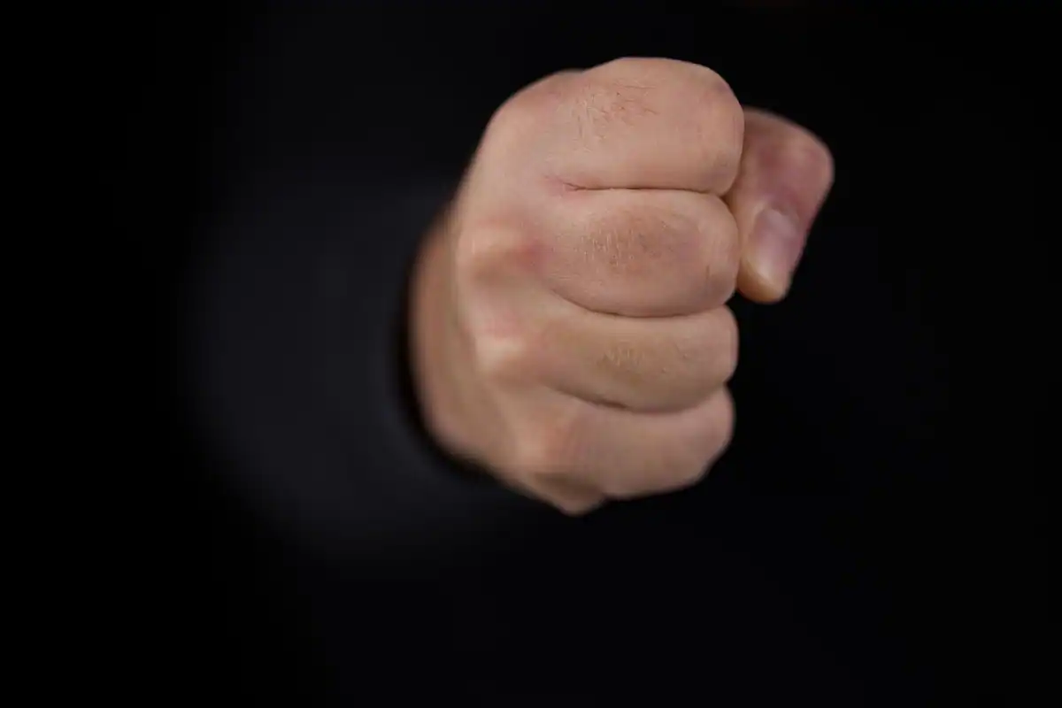 Pumn strâns pe fundal negru, imagine a furiei reținute
