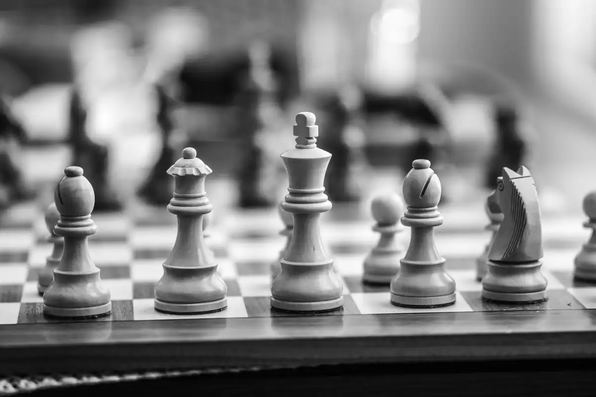 Piese de șah din lemn pe tablă, fotografie alb-negru despre strategie