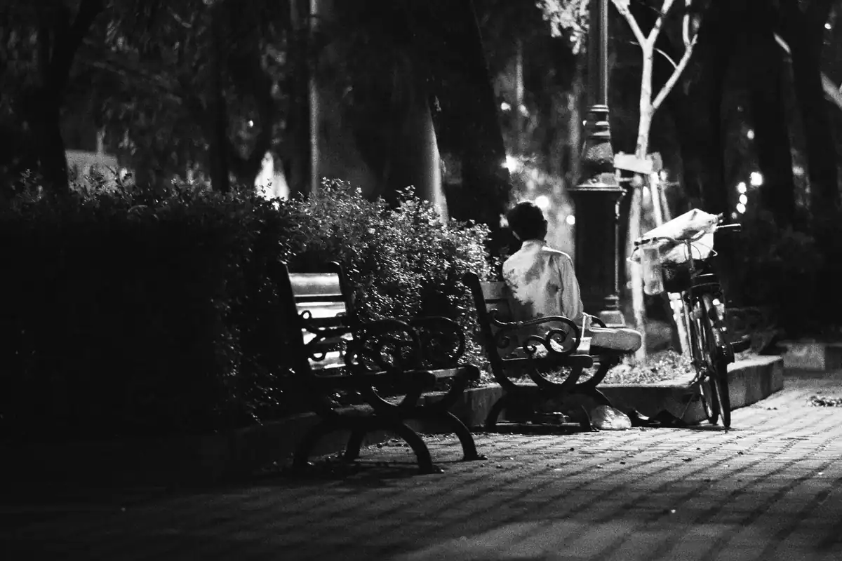 Om singur pe o bancă în parc noaptea, fotografie alb-negru