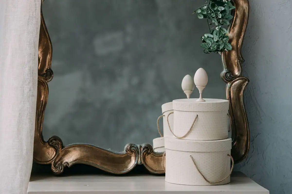 Oglindă ornamentată cu cutii decorative și verdeață