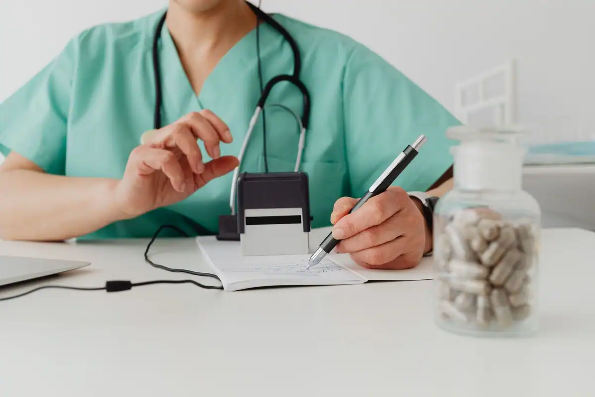 Medic care completează o rețetă într-un cabinet