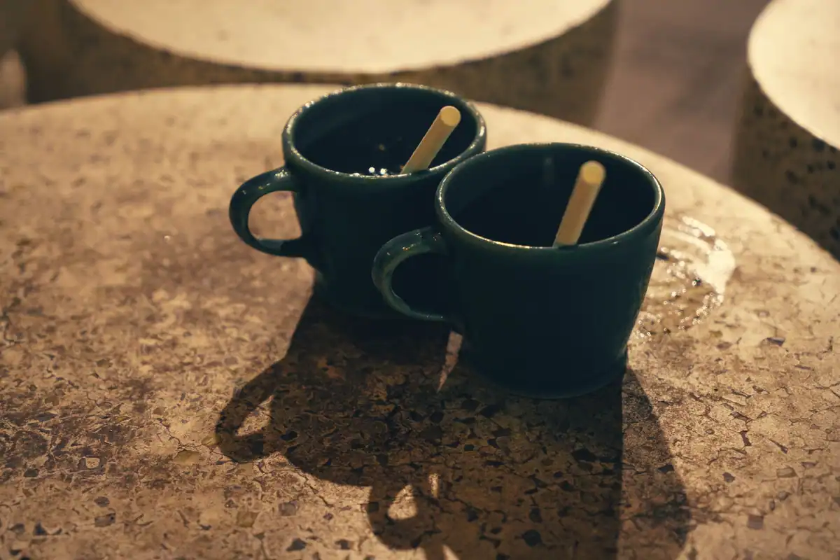 Două căni pe o masă de piatră într-o cafenea primitoare